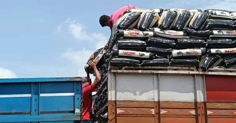 হিলি স্থলবন্দরে ট্রাক থেকে নামানো হচ্ছে চালের বস্তা